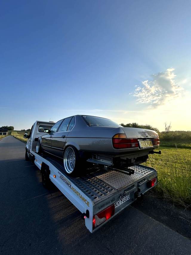 Transport klasycznego BMW serii 7 na lawecie MLAG o zachodzie słońca